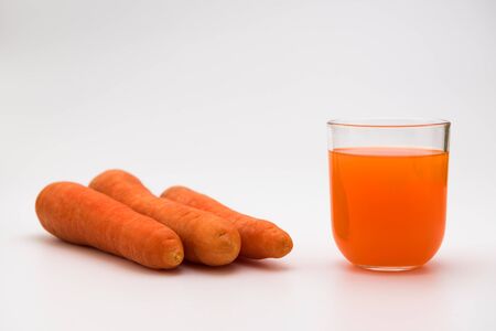 Fresh organic carrot juice. A glass of natural carrot juice and carrots isolated on a white background.の写真素材