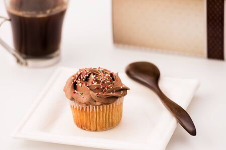 Chocolate muffins on a white background with a cup of coffee and wooden spoon. Homemade baking, Selective focus, close up.の写真素材