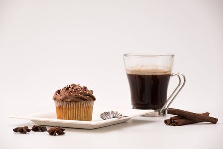 Chocolate Muffin with hot Cup of coffee, cinnamon sticks and Anise stars on a white backgroundの写真素材