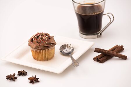 Chocolate Muffin with hot Cup of coffee, cinnamon sticks and Anise stars on a white backgroundの写真素材