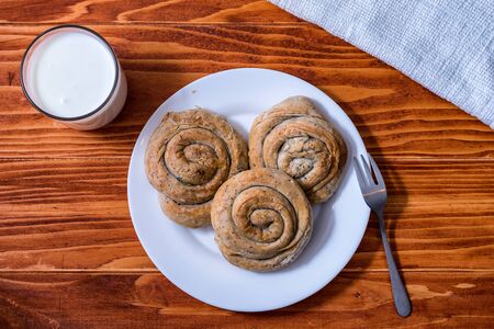 Domestic Home made Rolled pastry with spinach and cheese on a napkin with a glass of Yogurtの写真素材