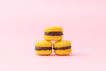 Tasty yellow french macarons on a pink pastel background. Close-up. Place for text.の写真素材