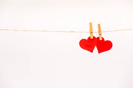 Clothes pegs and two red paper hearts on rope isolated on white background. Valentines day conceptの写真素材