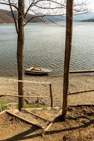 Boat on lake against mountains. Fishing boat on a still lake and mountains in background. Fishing boatの写真素材