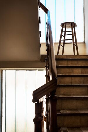 Old wooden Bar Stool in a Wooden Staircase with Handrailing in an Old house. Interior Decor of old Stairs. Old House Design Detail with Bar Stool and Stair Case with No Peopleの写真素材