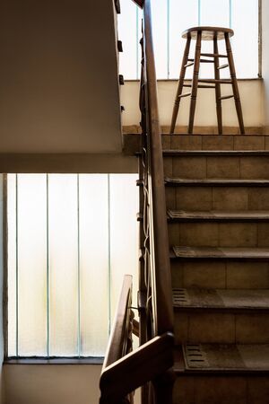 Old wooden Bar Stool in a Wooden Staircase with Handrailing in an Old house. Interior Decor of old Stairs. Old House Design Detail with Bar Stool and Stair Case with No Peopleの写真素材