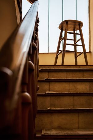 Old wooden Bar Stool in a Wooden Staircase with Handrailing in an Old house. Interior Decor of old Stairs. Old House Design Detail with Bar Stool and Stair Case with No Peopleの写真素材