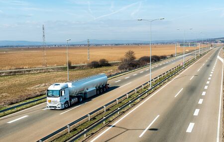 White Tank truck or cistern on a Highway through the rural landscape. Business Transportation And Trucking Industry.の写真素材