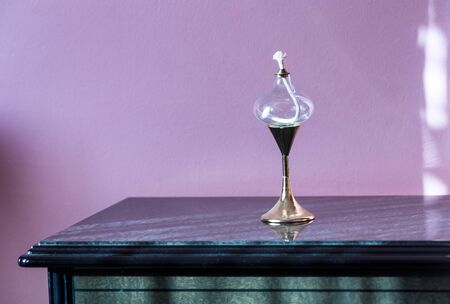 Antique vintage glass oil lamp  on a dusty Cupboard in the morning sunlightの写真素材
