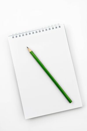 Open notebook with green Graphite pencil on a white office tableの写真素材