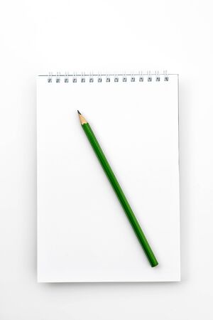 Open notebook with green Graphite pencil on a white office tableの写真素材