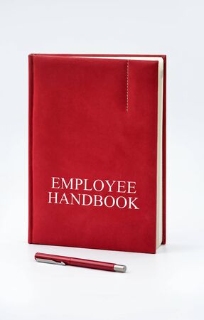 Employee Handbook or manual with a pen and paper on a white table in an office - personnel management policy, explains business goals, results, defines personnel practicesの写真素材