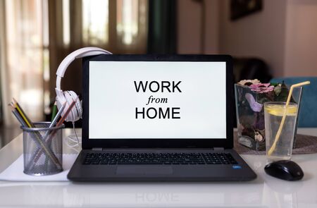 Work from home during Coronavirus pandemic quarantine isolation. Working remotely home concept. Comfortable working place in home office with laptop on the table with Headphonesの写真素材