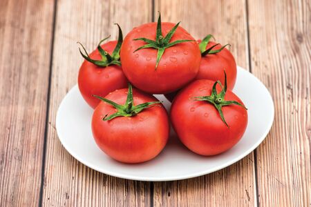 Raw ripe pink heirloom organic tomatoes on wooden background. Vegetarian - Vegan healthy diet culinary cooking concept - Top Viewの写真素材