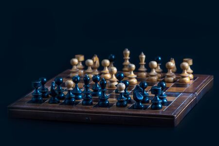 Old chess figures on a wooden board. Occupation on vacation and recreation - old chess set.の写真素材