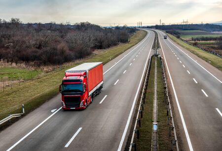 Red truck on a beautiful country highway road - business, commercial, cargo transportation conceptの写真素材