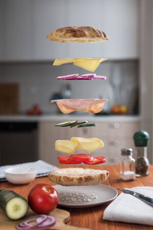 Levitating Sandwich with its ingredients. Deconstructed sandwich layers in kitchenの写真素材