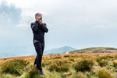 Photographer with old analog camera at a Mountain top. Mountain landscape view. Mountain layers landscape. 

Meadows and mountains landscape. Blue mountains layers landscape. Top of the Mountainsの写真素材