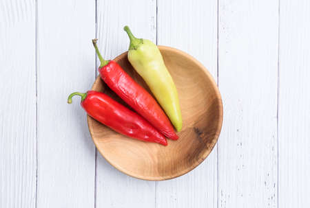 Red and Green chili raw peppers in a wooden bowl. Ripe peppers Close up. Copy space.の写真素材