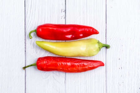 Red and Green chili peppers on white wooden table. Spice for cooking menu in kitchenの写真素材