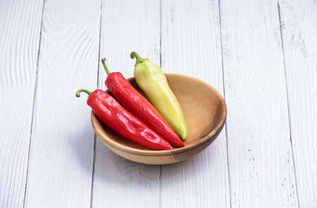Red and Green chili raw peppers in a wooden bowl. Ripe peppers Close up. Copy space.の写真素材
