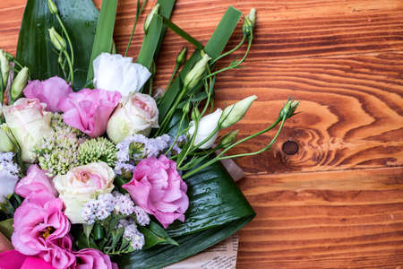 Roses flower bouquet on a wooden table. Pink, white and yellow roses, copyspaceの写真素材