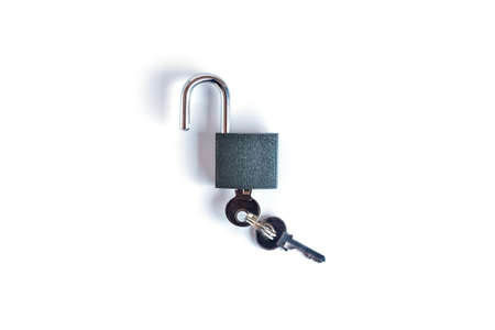 Lock and keys. Closeup of opened metal padlock with key inside isolated on a white background. Macro...