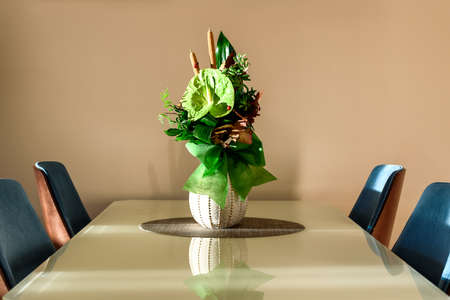 Green Anthurium andraeanum flower setup in a vase on glass dininig table in living room. Air purifying plants in the home decorの写真素材