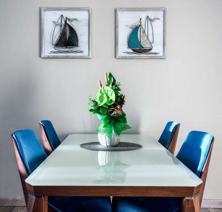 Green Anthurium andraeanum flower setup in a vase on glass dininig table in living room. Air purifying plants in the home decorの写真素材