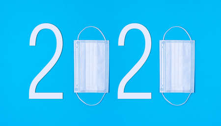 Coronavirus Concept Date of 2020 with masks instead of zeros over blue backgroundの写真素材