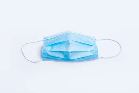Surgical protective mask on white background. Blue medical mask for protection against influenza, coronavirus and other viruses.の写真素材