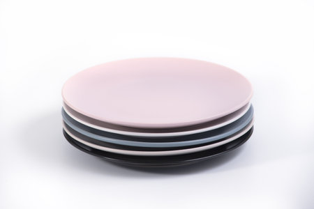 Stack of five colorful empty plates isolated on white background, side view. Pink, White, Navy Blue, Grey and Black empty plates collectionの写真素材