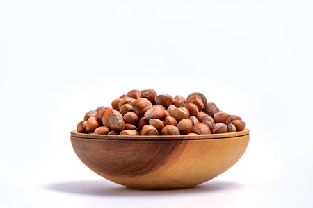 Hazelnuts in a wooden bowl on white background. Solid ripe Hazelnutsの写真素材