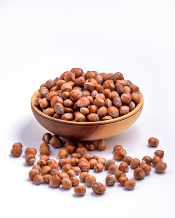Hazelnuts in a wooden bowl on white background. Solid ripe Hazelnutsの写真素材