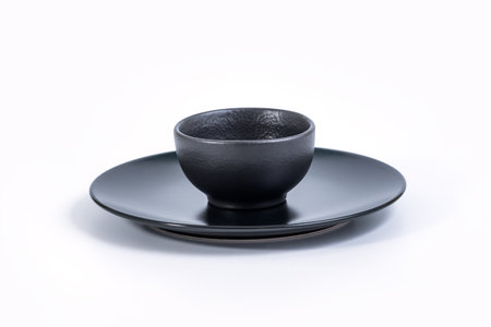 Black Bowl in Black Plate isolated on white background, side view.の写真素材