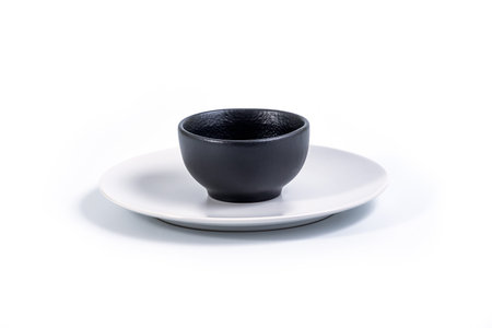 Black Bowl in White Plate on Whiteの写真素材