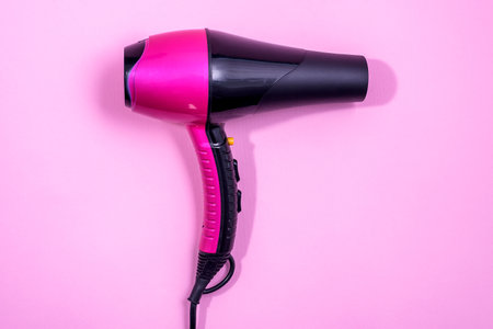 Black and Pink Hairdryer on light pink background - hairstyle toolの写真素材