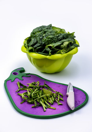 Fresh chopped spinach on a cutting board. Juicy green spinach, white background