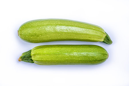 Courgette or Zucchini - green spotted vegetable for cooking vegetarian and healthy food, agricultural product isolated on white backgroundの写真素材