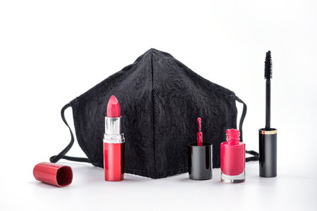 Beauty Concept during Coronavirus pandemic - Female black protective mask with beauty makeup - lipstick, 

nail polish and mascara on white background. Women not giving up their beautyの写真素材