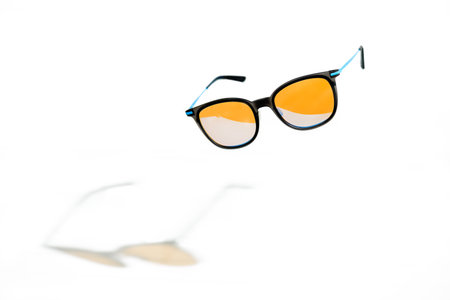 Conceptual elegant Sunglasses hovering isolated on white background. Sun glasses summer accessories as design element for promo or advertising banner. High quality photoSunglasses hovering on white baの写真素材