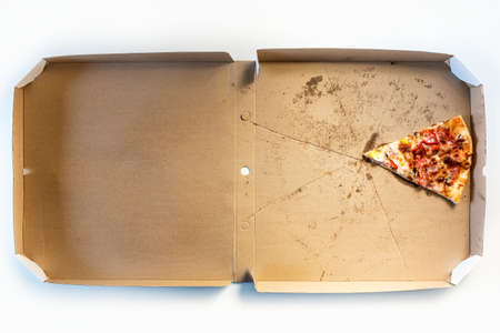 Last slice of pizza in a delivery cardboard box. Concept for home delivery of food, fast food,...