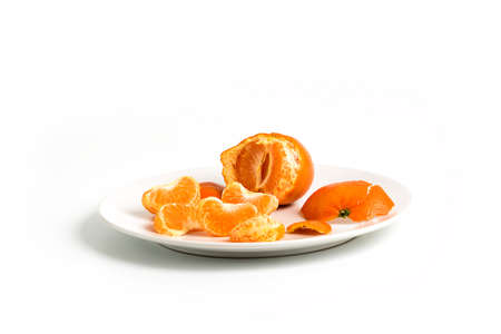 Peeling Tangerines or Clementines in White Plate, isolated on white backgroundの写真素材