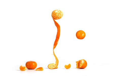 Peeling Tangerines or Clementines with some hovering in the air, isolated on white backgroundの写真素材