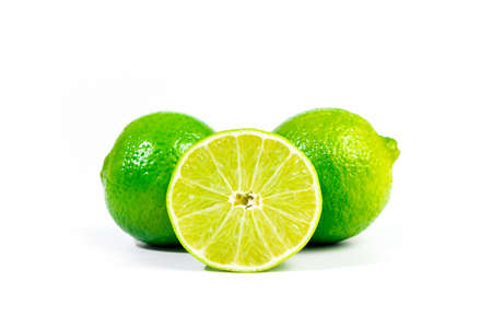 Whole limes and halfe of lime fruit close up with selective focus, isolated on white backgroundの写真素材