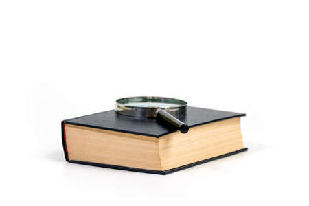 Book with magnifying glass on white background. Concept of research and search for knowledget.の写真素材