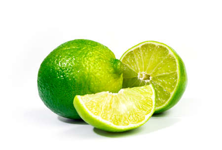 Whole lime and half of lime fruit close up with selective focus, isolated on white backgroundの写真素材
