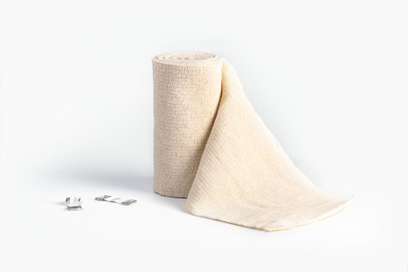 Woven elastic medical bandage rolled into roll and fixation clips. Compression Bandage on 

a white backgroundの写真素材