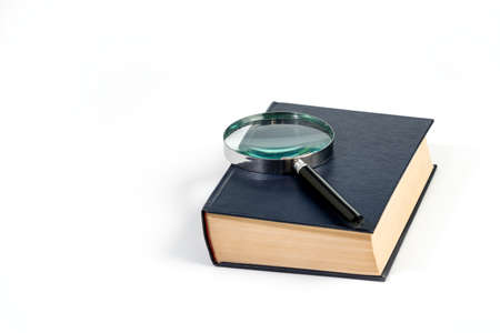 Book with magnifying glass on white background. Concept of research and search for knowledge.の写真素材