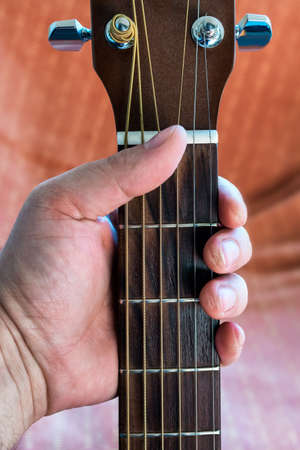 Guitarist fingers calluses with acoustic guitar fretboard